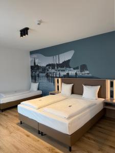 a bedroom with a large bed with a painting on the wall at Central Hotel in Flensburg +36 photos