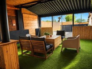 a patio with a wooden table and chairs on grass at Finca Sueño Crea in Lorca