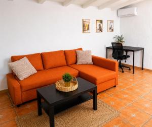 an orange couch in a living room with a table at Finca Sueño Crea in Lorca +40 photos