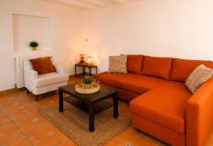 a living room with an orange couch and a coffee table at Finca Sueño Crea in Lorca