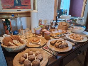 a table with many different types of pastries on it at B&b CASCINA CORNELLA in Cremeno