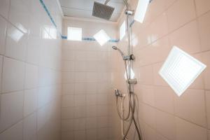 a shower with a shower head in a bathroom at Gîte L'inattendue in Courseulles-sur-Mer +12 photos