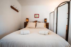 a bedroom with a large white bed with two pillows at Gîte L'inattendue in Courseulles-sur-Mer
