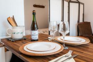 a table with a bottle of wine and two glasses at Gîte L'inattendue in Courseulles-sur-Mer