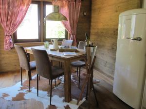 a dining room with a table and a refrigerator at Chalet Tirolia in Kirchdorf in Tirol