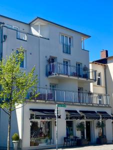 a white building with blue balconies on it at Kirchenplatz 6 Apartment 18 Atlantic in Warnemünde
