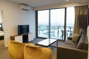 a living room with a couch and a tv at Quest East Perth in Perth
