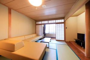 a living room with a couch and a tv at ゆるり奥日光withDOGS in Nikko