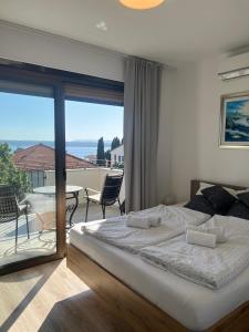 a bedroom with a bed and a balcony with a view at Vila Peričić in Dramalj