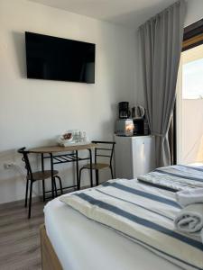a bedroom with a bed and a table and a television at Vila Peričić in Dramalj
