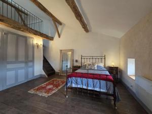a bedroom with a bed with a red blanket on it at Maison centre historique in Lectoure