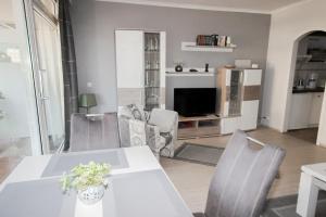 a living room with a white table and chairs at Brandungsbad 36 in Grömitz