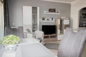 a living room with a table and chairs and a television at Brandungsbad 36 in Grömitz