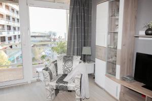 a living room with a couch and a large window at Brandungsbad 36 in Grömitz