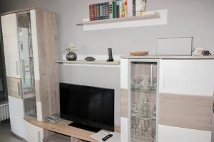 a living room with a tv and a book shelf at Brandungsbad 36 in Grömitz