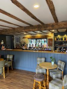 a bar in a restaurant with a table and chairs at The Bell Inn in Stroud