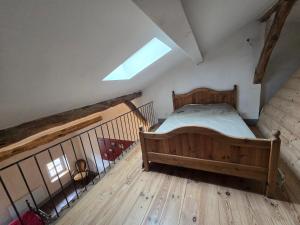 a bedroom with a bed and a staircase with a skylight at Maison centre historique in Lectoure