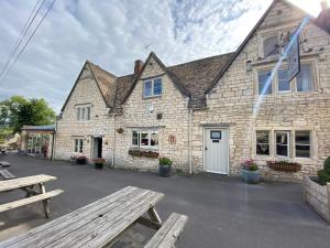 a stone building with a picnic table in front of it at The Bell Inn in Stroud +9 photos