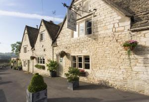 a white brick building with potted plants on it at The Bell Inn in Stroud
