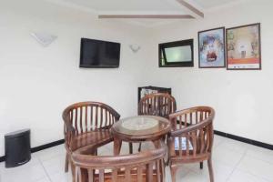 a room with a table and four chairs and a tv at Hotel Lestari Near Lippo Plaza Mall Jember in Jember