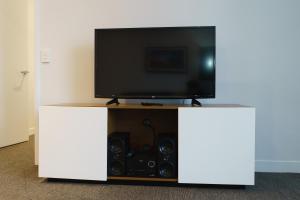 a white entertainment center with a flat screen tv at Quest East Perth in Perth