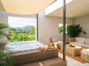 a hot tub in a living room with a large window at Villa COLORS by Relapool in Inbu