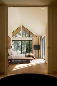 a bedroom with a bed and a large window at The Vale Penrose in Penrose