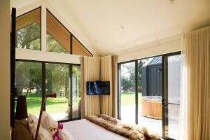 a bedroom with a bed and a large window at The Vale Penrose in Penrose