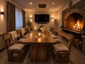 a dining room with a long table and a fireplace at Holiday house "Mimoza" 2 massage pools in Otočac