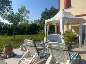 a couple of lawn chairs and a gazebo at Tenuta Crescentini-ValleMura ,appartamenti con entrata indipendente in San Donà di Piave