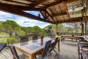 a dining room with a table and chairs on a deck at Villa dans Site Exceptionnel in Mourèze