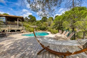 a hammock on a deck next to a pool at Villa dans Site Exceptionnel in Mourèze