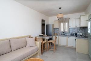 a living room with a couch and a kitchen at Small Cyclades Houses in Koufonisia