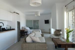 a white living room with a couch and a table at Chrysalis Nature Villa 9 in Kampos Paros