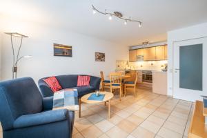 a living room with a couch and a table at Ferienwohnung Bäumer Borkum - Nichtraucher & allergikerfreundlich in Borkum +10 photos