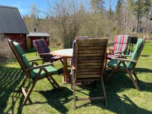 a group of four chairs and a table in the grass at 5 person holiday home in ULRIKA in Rimforsa