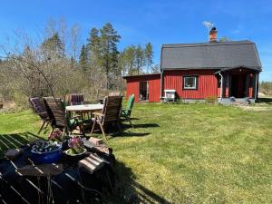 a table and chairs in front of a red barn at 5 person holiday home in ULRIKA in Rimforsa