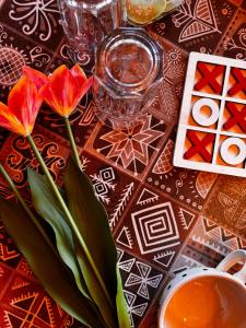 a table with red flowers in a vase on a table at Nirvana Trueliving in Nagar +178 photos
