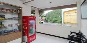 a coca cola machine in a room with a window at Hotel Lestari Near Lippo Plaza Mall Jember in Jember +12 photos