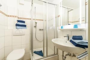 a bathroom with a shower and a sink and a toilet at Ferienwohnung Bäumer Borkum - Nichtraucher & allergikerfreundlich in Borkum