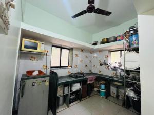a kitchen with a sink and a refrigerator at Sukrut Villa, Alibag in Thāl