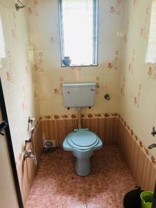 a bathroom with a toilet and a window in it at Sukrut Villa, Alibag in Thāl +10 photos