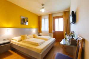 a hotel room with a bed and a table at Weingut Franz Schindler in Mörbisch am See