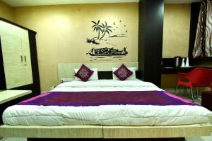 a bedroom with a large bed with purple sheets at Hotel Gulmohar in Indore