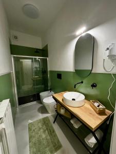 a green bathroom with a sink and a toilet at Il Ritrovo dei Sogni in Palazzolo Vercellese