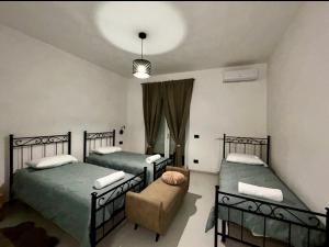 a bedroom with two beds and a couch in it at Il Ritrovo dei Sogni in Palazzolo Vercellese