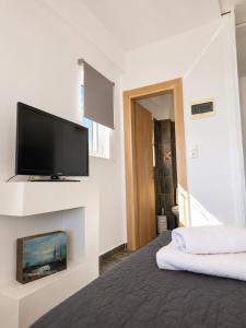 a bedroom with a flat screen tv on a wall at Calypso Private Estate in Xiropigado