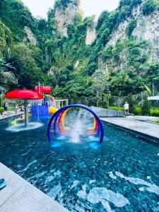 a pool with a rainbow in the water at The Cove Hillside@Loft in Ipoh