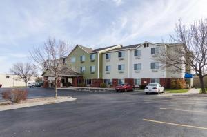 un gran edificio con coches estacionados en un estacionamiento en Motel 6-Lincoln, NE, en Lincoln