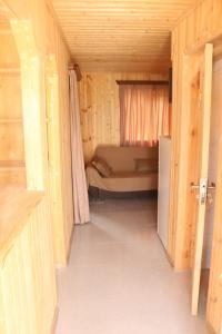 a small room with a bed in a wooden house at Katie in Tianeti in Zhebota